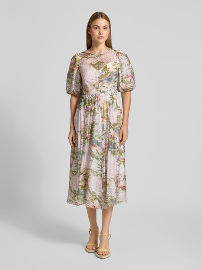 Modelka nosi Midikleid mit Puffärmeln Modell 'JONORA' od Ted Baker, lyocellowy miks, krój taliowany, okrągły dekolt, bufiaste rękawy, wycięcie i wiązanie z tyłu, tylny zamek, długość tyłu w rozmiarze 36: 103 cm, szerokość w rozmiarze 36: 37 cm, długość rękawa w rozmiarze 36: 33 cm, pastelowe kwiatowe wzory, tekstura lekka, widok całej sylwetki z przodu.