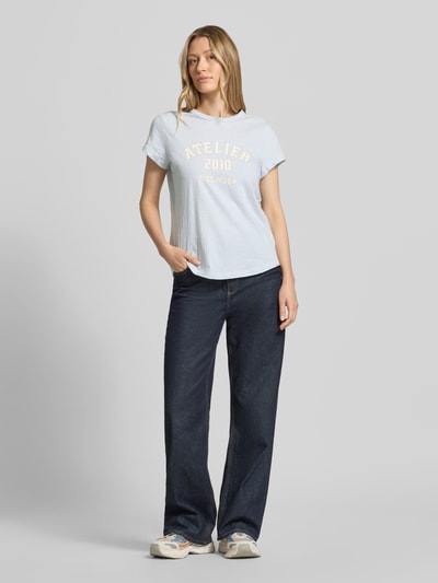 Frauenmodel trägt Regular Fit T-Shirt mit Logo-Print von MOS MOSH, Damen T-Shirt aus Reine Baumwolle, Rundhalsausschnitt, Rückenlänge 63 cm, helle Farben, schlichte Struktur, Ganzkörperansicht von vorne.