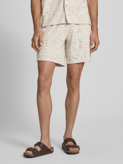 Männermodel trägt Relaxed Fit Sweatshorts mit Baumwoll-Anteil Modell 'CLEMENT' von Only & Sons, sandfarbenes Allover-Muster, Frottee-Struktur, seitliche Eingrifftaschen, elastischer Bund mit Tunnelzug, Ganzkörperansicht von vorne.