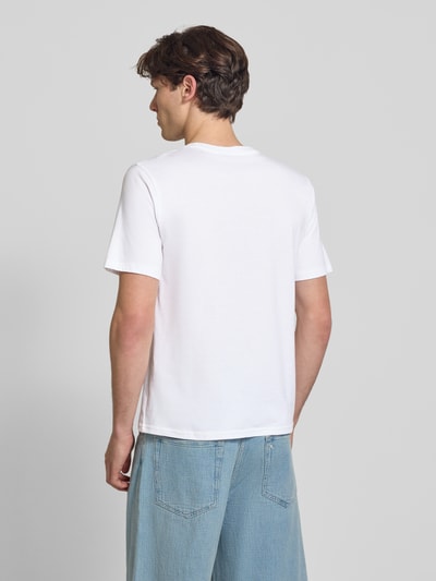 Männermodel trägt Regular Fit T-Shirt mit Logo-Print Modell 'Buster' von JACK & JONES aus Reine Baumwolle, Rückenlänge 71 cm, Ganzkörperansicht Rückansicht.