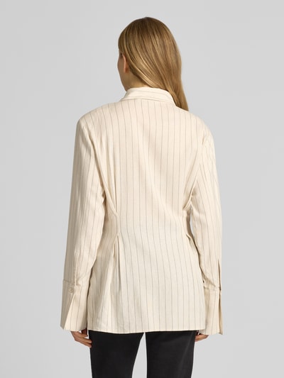 Frauenmodel trägt Hemdbluse aus Viskose-Mix Modell 'Tascha' von Gestuz in Beige mit feinen Streifen, taillierte Passform, Ganzkörperansicht Rückansicht.
