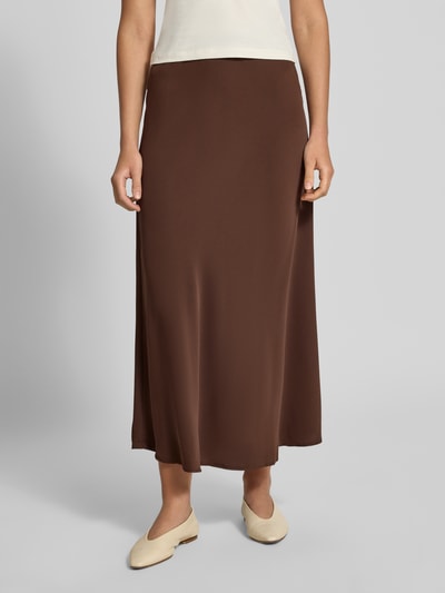 Frauenmodel trägt ausgestellten Maxi-Rock mit elastischem Bund Modell 'FRANAN' von PIECES in Braun, glatte Textur, Ganzkörperansicht von vorne. Damen Maxi-Rock von PIECES.