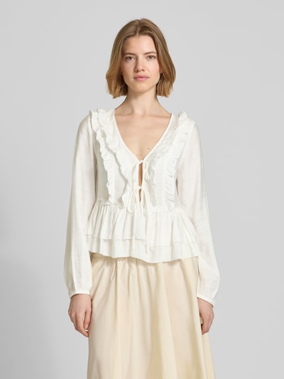 Frauenmodel trägt Regular Fit Langarmbluse aus Viskose-Mix Modell 'ZOEY' von Vero Moda, unifarben, Flounce-Detail, Ganzkörperansicht von vorne.