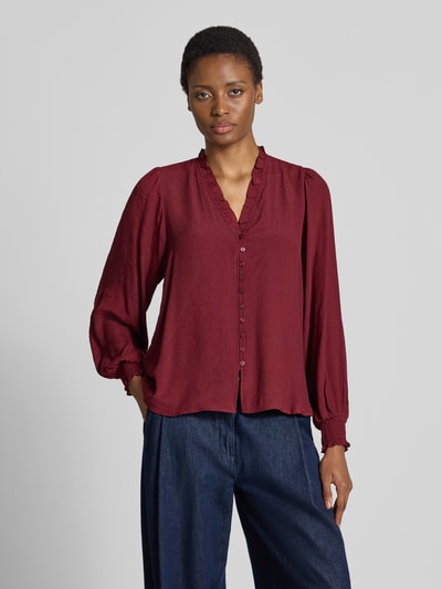 Frauenmodel trägt Regular Fit Bluse aus Viskose-Mix von Apricot in Dunkelrot mit V-Ausschnitt, Rüschen und Knopfleiste, Ganzkörperansicht von vorne.