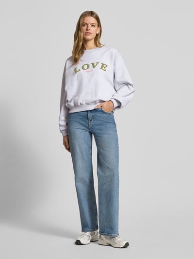 Frauenmodel trägt Sweatshirt mit Statement-Stitching und Rundhalsausschnitt von OH APRIL, Reine Baumwolle, Regular-Fit, Ganzkörperansicht von vorne.