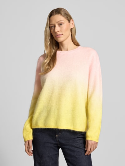 Frauenmodel trägt Regular Fit Pullover aus Kaschmir-Mix in Strick-Optik von HERZENS, gelb-pink Verlauf, Rundhalsausschnitt, elastische Abschlüsse, Ganzkörperansicht von vorne.