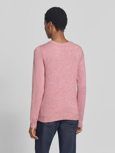 Frauenmodel trägt Strickpullover aus Viskose-Mix von VILA in Rosa, taillierte Passform mit gerippten Abschlüssen, Ganzkörperansicht Rückansicht.