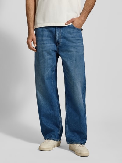 Männermodel trägt Barrel Jeans im Used-Look Modell 'LUCKY STAR' von Calvin Klein Jeans aus reiner Baumwolle in Blau, Ganzkörperansicht von vorne.