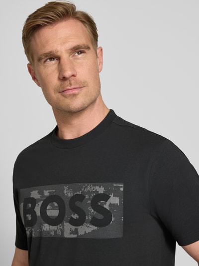 Mężczyzna nosi męski t-shirt Regular Fit T-Shirt aus Baumwoll-Mix Modell 'TS_GLOBE LOGOPATTERN' von BOSS Green, jednokolorowy, nadruk z logo, okrągły dekolt, krótki rękaw, mieszanka bawełny, zbliżenie na górę ciała