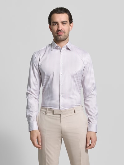 Männermodel trägt Slim Fit Businesshemd mit Kentkragen von Jake*s in Weiß mit feinen lilafarbenen Streifen, Ganzkörperansicht von vorne. Herren Businesshemd mit durchgehender Knopfleiste, elastischem Material-Mix, Langarm und Sportmanschetten.