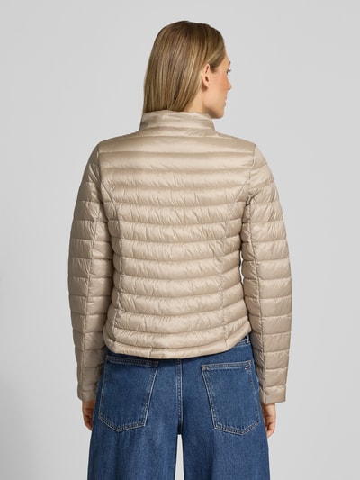 Frauenmodel trägt Steppjacke mit Stehkragen von Gil Bret in Beige, Körpernahe Passform, Reißverschlusstaschen, Rückenlänge 56 cm, Schulterbreite 39 cm, Brustweite 47 cm, Ärmellänge 66 cm, Zweiwege-Reißverschluss, Ganzkörperansicht Rückansicht.
