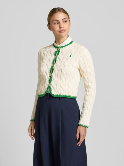 Frauenmodel trägt Regular Fit Sweatjacke aus Baumwoll-Mix von Polo Ralph Lauren in Unifarben Creme mit grünem Saum, Strickstruktur, Logo-Stitching, lange Ärmel, Rundhals, einreihige Knopfleiste, Ganzkörperansicht von vorne.