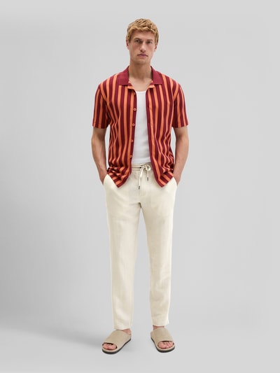 Männermodel trägt Regular Fit Freizeithemd aus reiner Baumwolle von Marc O'Polo in Rot mit gestreifter Strickoptik, Polokragen, einreihiger Knopfleiste, kurzärmelig, Webware, Ganzkörperansicht von vorne