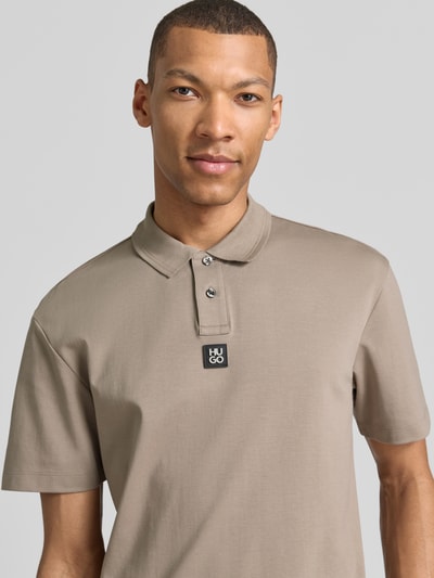 Männermodel trägt Regular Fit Poloshirt aus reiner Baumwolle Modell 'DEABONO' von HUGO, Optik: Unifarben, Nahaufnahme Oberkörper.