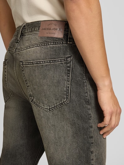 Männermodel trägt Wide Fit Jeans aus reiner Baumwolle Modell 'COOPER' von JACK & JONES, dunkle Waschung, 5-Pocket-Design, Nahaufnahme Rückansicht.