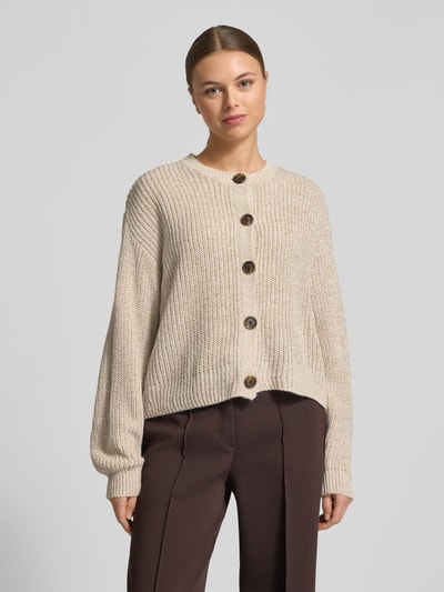 Modelka nosi Regular Fit Strickjacke mit einreihiger Knopfleiste Modell 'LEA' od Vero Moda, kremowy sweter o jednolitej fakturze, krój regular fit, bryłowe guziki, okrągły dekolt, długie rękawy, ściągacze, widok całej sylwetki z przodu.