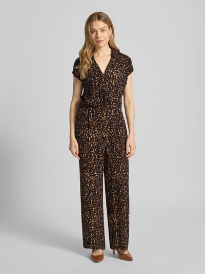 Modelka nosi Jumpsuit aus Viskose Modell 'MARRAKECH' od ICHI, czarny allover print, krój regular fit, długość całkowita 136 cm, szerokość w rozmiarze S 47 cm, widok całej sylwetki z przodu.