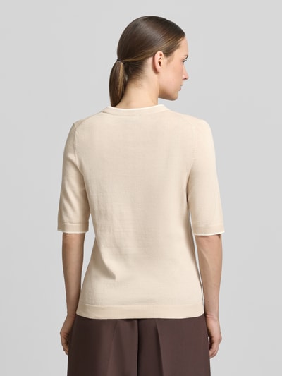 Kobiece model nosi Regular Fit T-Shirt aus Baumwoll-Modal-Mix von s.Oliver BLACK LABEL w imitacji dzianiny, krótki rękaw, okrągły dekolt, mieszanka bawełny i modalu, wykończenia prążkowane, kolor jasny beż, widok całej sylwetki z tyłu.