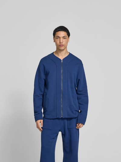 Männermodel trägt Sweatjacke mit Reißverschluss von Kenzo in Blau, Relaxed-Fit, Reine Baumwolle, Eingrifftaschen, Ganzkörperansicht von vorne.