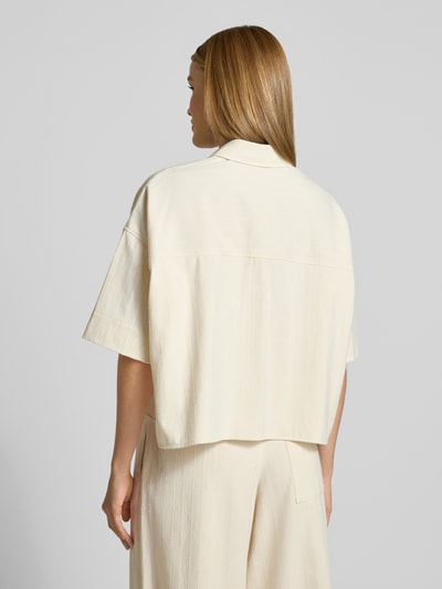 Männermodel trägt Boxy Fit Bluse mit 1/2-Arm Modell 'YARIKA' von Drykorn, mieszanka bawełny i kaszmiru, kolor kremowy, kołnierzyk koszulowy, długość tyłu 54 cm, długość rękawów 22 cm, pudełkowy krój, Ganzkörperansicht Rückansicht.