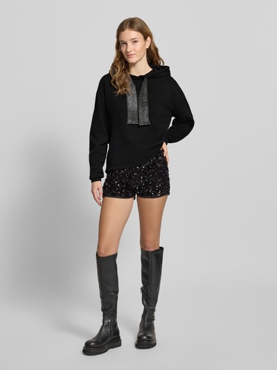 Modelka nosi Regular Fit Hoodie aus Baumwoll-Mix Modell 'CHILLI' od Pieces, kolor jednolity, długi rękaw, ściągacz, kieszonka z przodu, widok całej sylwetki z przodu.