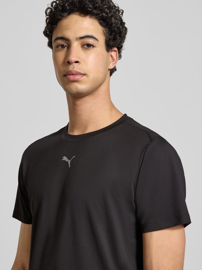 Männermodel trägt Regular Fit T-Shirt mit Rundhalsausschnitt von PUMA PERFORMANCE, Baumwoll-Viskose-Mix, Logo-Print, Nahaufnahme Oberkörper.