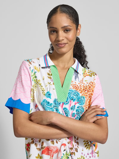 Vrouwenmodel draagt Blusenshirt aus Seide-Elasthan-Mix im Allover-Look van HERZENS met bloemenprint, regular fit, omgeslagen kraag, V-hals, ruglengte 66 cm, mouwlengte 25 cm, vooraanzicht close-up.