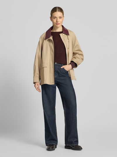 Frauenmodel trägt Regular Fit Langarmshirt aus reiner Baumwolle von Marc O'Polo in Dunkelrot, kombiniert mit heller Jacke und blauen Jeans, Ganzkörperansicht von vorne, Damen Langarmshirt von Marc O'Polo.
