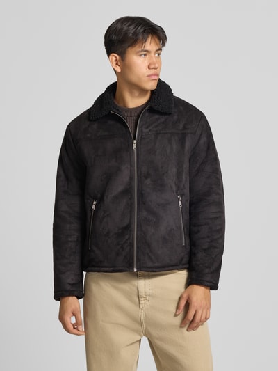 Männermodel trägt Jacke in Leder-Optik mit Reißverschlusstaschen von REVIEW in Schwarz, Umlegekragen, Regular Fit, Ganzkörperansicht von vorne.
