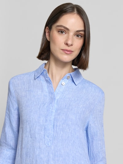 Frauenmodel trägt Knielanges Hemdblusenkleid aus Leinen mit 3/4-Arm von Christian Berg Woman in Hellblau, sichtbare Leinenstruktur, Hemdblusenkragen, verdeckte Knopfleiste, A-Linie, Nahaufnahme Oberkörper. Rückenlänge 96 cm, Brustweite 54 cm, Ärmellänge 41 cm, Größe 36.