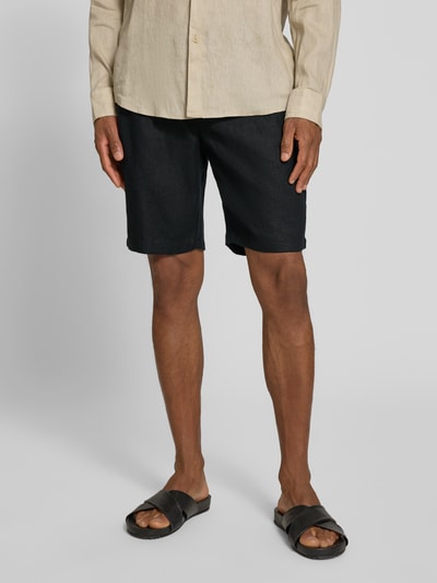 Mężczyzna nosi Leinen Shorts mit Eingrifftaschen Modell 'PANDRUP' od Casual Friday, czarny len, krój straight fit, Szerokość w rozmiarze M: 44 cm, długość nogawki wewnętrznej: 23 cm, widok całej sylwetki z przodu