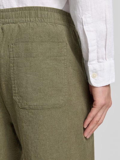 Männermodel trägt Leinenshorts mit elastischem Bund von GAP im Leinen-Baumwoll-Mix, Loose-Fit, Gesäßtasche, Nahaufnahme Rückansicht.