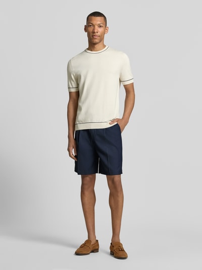 Męski model nosi Loose Fit Bermudy z dodatkiem wełny model 'OTTO' od SELECTED HOMME, efekt: jednolity kolor, krój loose fit, szlufki na pasek, zakładki w pasie, zapięcie na guzik i ukryty zamek błyskawiczny, wpuszczane kieszenie, kieszenie z wypustkami. Ganzkörperansicht von vorne.