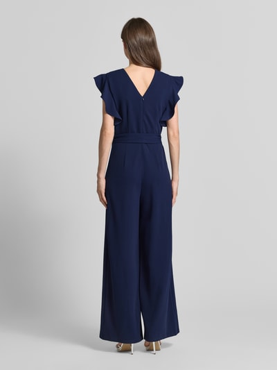 Vrouwenmodel draagt Jumpsuit met Bindegürtel und Eingrifftaschen van Apricot in donkerblauw materiaalmix met stretch, regular fit, ronde hals, strikceintuur en steekzakken, ruglengte maat S 36 cm, borstwijdte maat S 45 cm, totale lengte maat S 150 cm, binnenbeenlengte maat S 112 cm. Ganzkörperansicht Rückansicht.