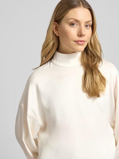Kobieta modelka nosi bluzkę Relaxed Fit Bluse mit Stehkragen Modell 'ALVARA' od Drykorn, mieszanka materiałów z dodatkiem streczu, kolor jasny, gładka tekstura, długość tyłu w rozmiarze 36: 58 cm, długość rękawów w rozmiarze 36: 46 cm, ujęcie: zbliżenie na górną część ciała z przodu.
