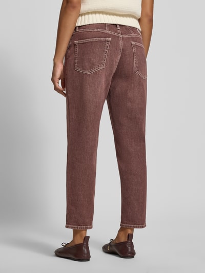 Frauenmodel trägt Tapered Fit Jeans aus Baumwoll-Mix Modell 'MILEY' von Brax in brauner Denim-Optik mit fixiertem Umschlag, Ganzkörperansicht Rückansicht.