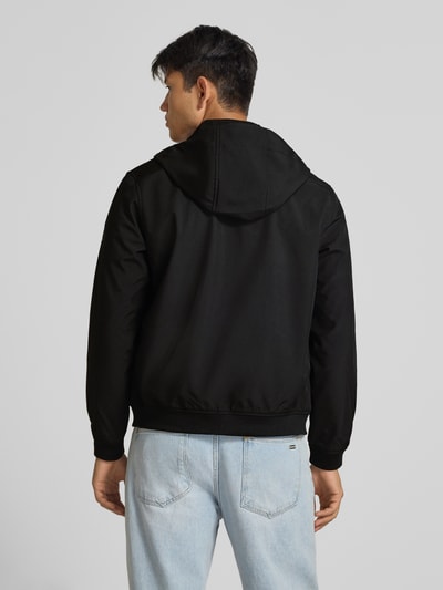 Männermodel trägt Regular Fit Jacke mit Logo-Detail von JACK & JONES in Schwarz, Softshell mit Kapuze, Rückenansicht, Ganzkörperansicht Rückansicht.