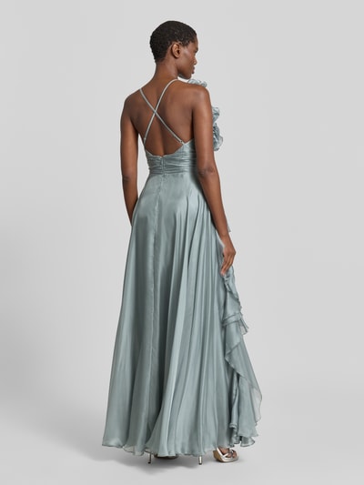 Modelka nosi 'Abendkleid mit Volants und Herz-Ausschnitt' od V.M., satyna, A-linia, długie, odkryte plecy, falbany, zapięcie na zamek i haftki z tyłu, błękitnoszary kolor, Szerokość w rozmiarze 36: 32 cm, długość pleców: 122 cm, widok całej sylwetki z tyłu.