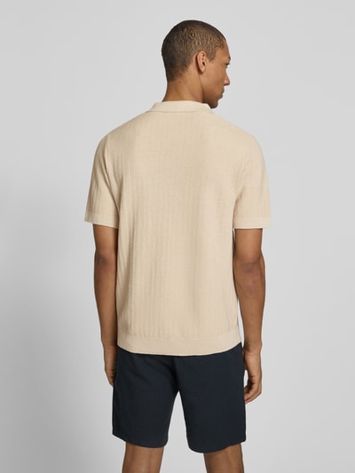 Męski model nosi Regular Fit Poloshirt aus Baumwoll-Leinen-Mix Modell 'MATTIS' od SELECTED HOMME, gładka struktura, krój regular fit, krótki rękaw, jasny beż, widok całej sylwetki z tyłu.