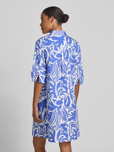 Frauenmodel trägt Knielanges Hemdblusenkleid mit verdeckter Knopfleiste von Christian Berg Woman aus Reine Baumwolle mit Straight Fit und Hemdblusenkragen, 1/2-Arm, weiß-blaues Muster, glatte Textur, Ganzkörperansicht Rückansicht.