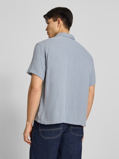 Männermodel trägt Regular Fit Freizeithemd mit Kentkragen von Jack & JonesR in Hellblau, reine Baumwolle, Halbarm, lockerer Schnitt, Ganzkörperansicht Rückansicht.
