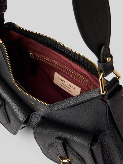 Produktfoto, Shoulder Bag mit Logo-Detail Modell 'Mavery' von Coccinelle, schwarze Lederstruktur, Reißverschluss, rotes Innenfutter, goldfarbene Metallteile, Hauptfach und Taschen, Kontext: Damen Shoulder Bag von Coccinelle, Hauptfach mit Reißverschluss, Schulterriemen, Modell 'Mavery', Logo-Detail, Maße: Breite 22 cm, Länge 21 cm, Tiefe 6 cm, Schulterriemen 73 cm.