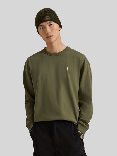 Männermodel trägt Relaxed Fit Langarmshirt aus reiner Baumwolle von Polo Ralph Lauren in Olivgrün mit glatter Textur, Nahaufnahme Oberkörper. Herren Langarmshirt von Polo Ralph Lauren