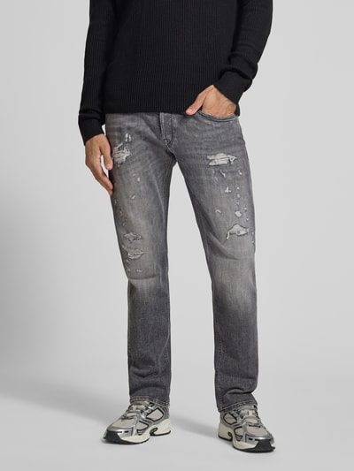 Männermodel trägt Straight Fit Jeans im Used-Look Modell 'Grover' von Replay, 5-Pocket-Design, graue Waschung, Ganzkörperansicht von vorne. Baumwoll-Mix mit Stretch-Anteil, Knopf- und Reißverschluss, Bundweite 46 cm, Innenbeinlänge 82 cm.