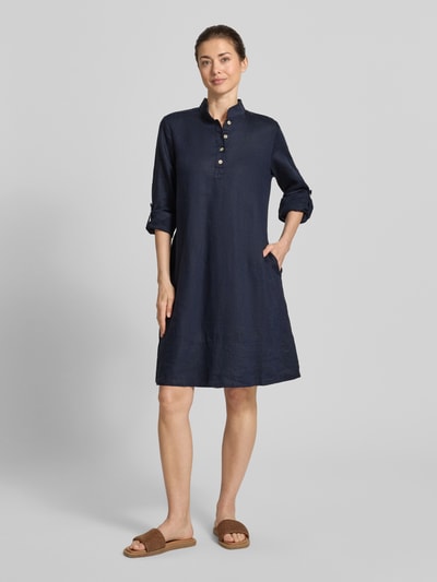 Frauenmodel trägt Leinenkleid mit Stehkragen und kurzer Knopfleiste von Christian Berg Woman in Dunkelblau, Gerader-Schnitt, Knielänge, Reine Leinen, Ärmel mit Aufschlag, Rückenlänge 99 cm, Brustweite 49 cm, Ärmellänge 63 cm, Ganzkörperansicht von vorne.