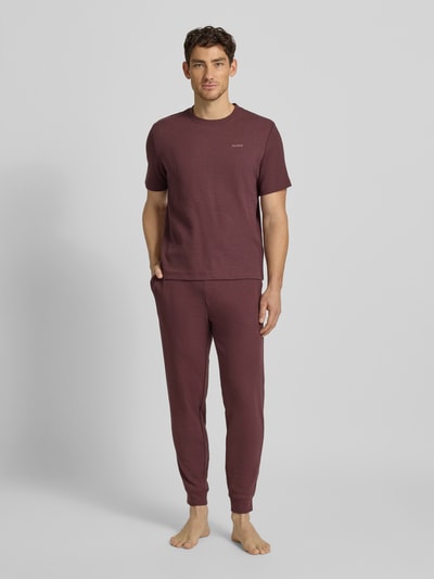 Männermodel trägt Regular Fit T-Shirt aus Baumwoll-Mix Modell 'AUSTIN' von HUGO in Unifarben mit Waffel-Struktur, Ganzkörperansicht von vorne.