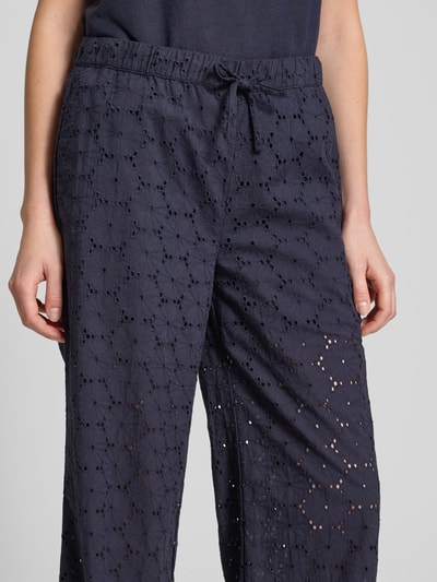 Frauenmodel trägt Stoffhose mit Lochstickerei von Christian Berg Woman aus Reine Baumwolle in Navy, elastischer Bund, Nahaufnahme Oberkörper.