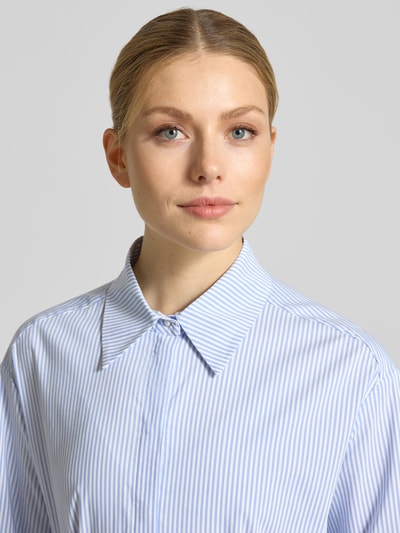 Frauenmodel trägt Hemdblusenkleid mit verdeckter Knopfleiste und Bindegürtel von Marc Cain aus Baumwoll-Mix mit Stretch-Anteil, Nahaufnahme Oberkörper.