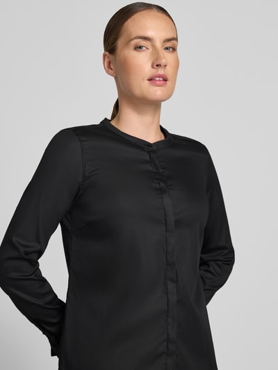 Kobiece model nosi bluzkę z mieszanki bawełny z dodatkiem streczu MOS MOSH, Model 'Mattie', stójka, listwa guzikowa, rękawy z falbanami, czarna, prosty krój, długość tyłu w rozmiarze S: 63 cm, długość rękawów w rozmiarze S: 62 cm, zdjęcie całej sylwetki od przodu.