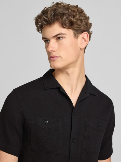 Männermodel trägt Regular Fit Freizeithemd mit Kentkragen und Brusttaschen von Superdry, Reine Baumwolle, Strukturmuster, Nahaufnahme Oberkörper.